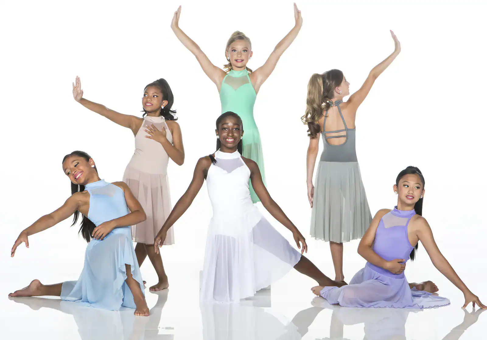 Six young dancers posing in pastel costumes on white background.