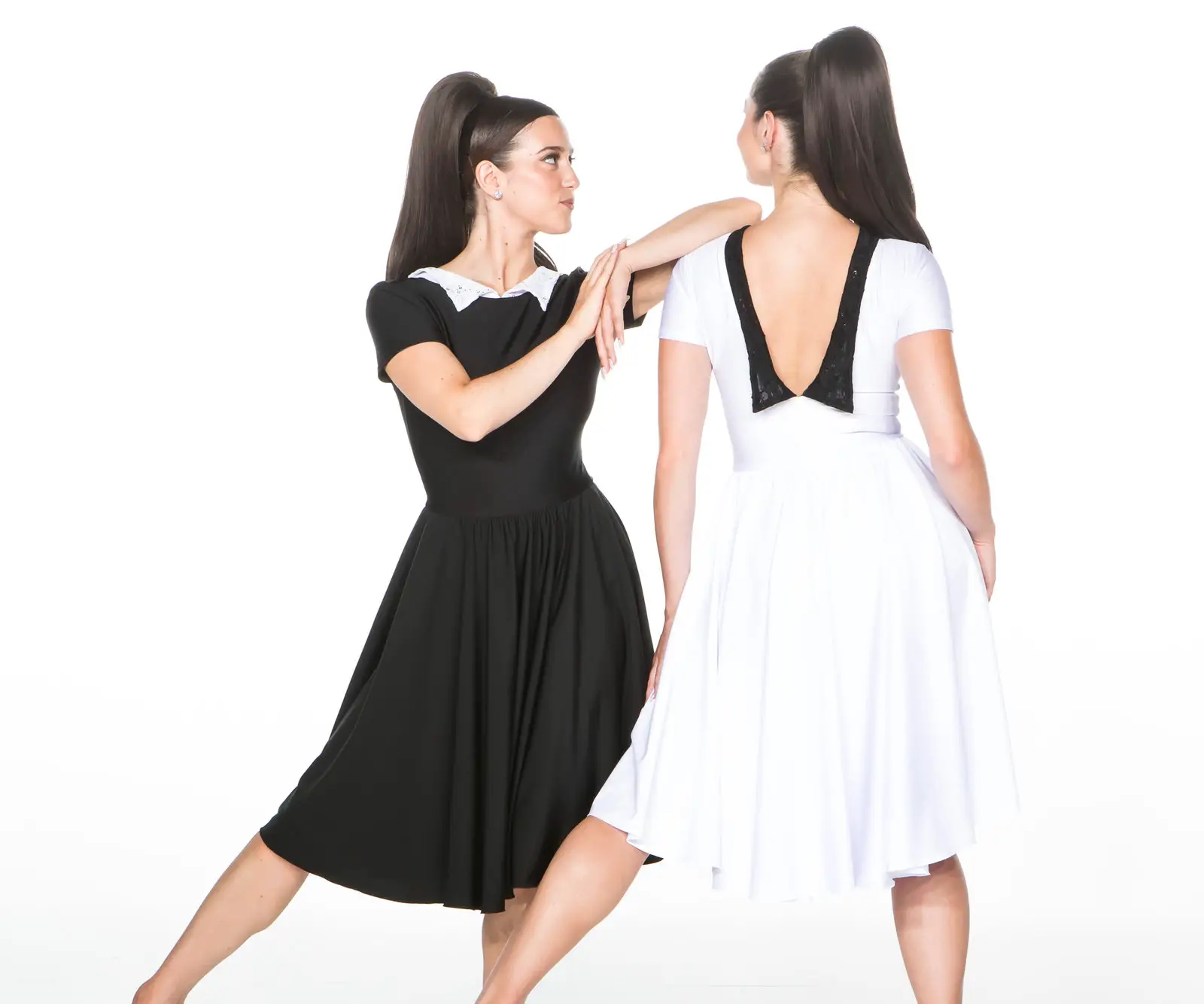 Two women modeling black and white dresses