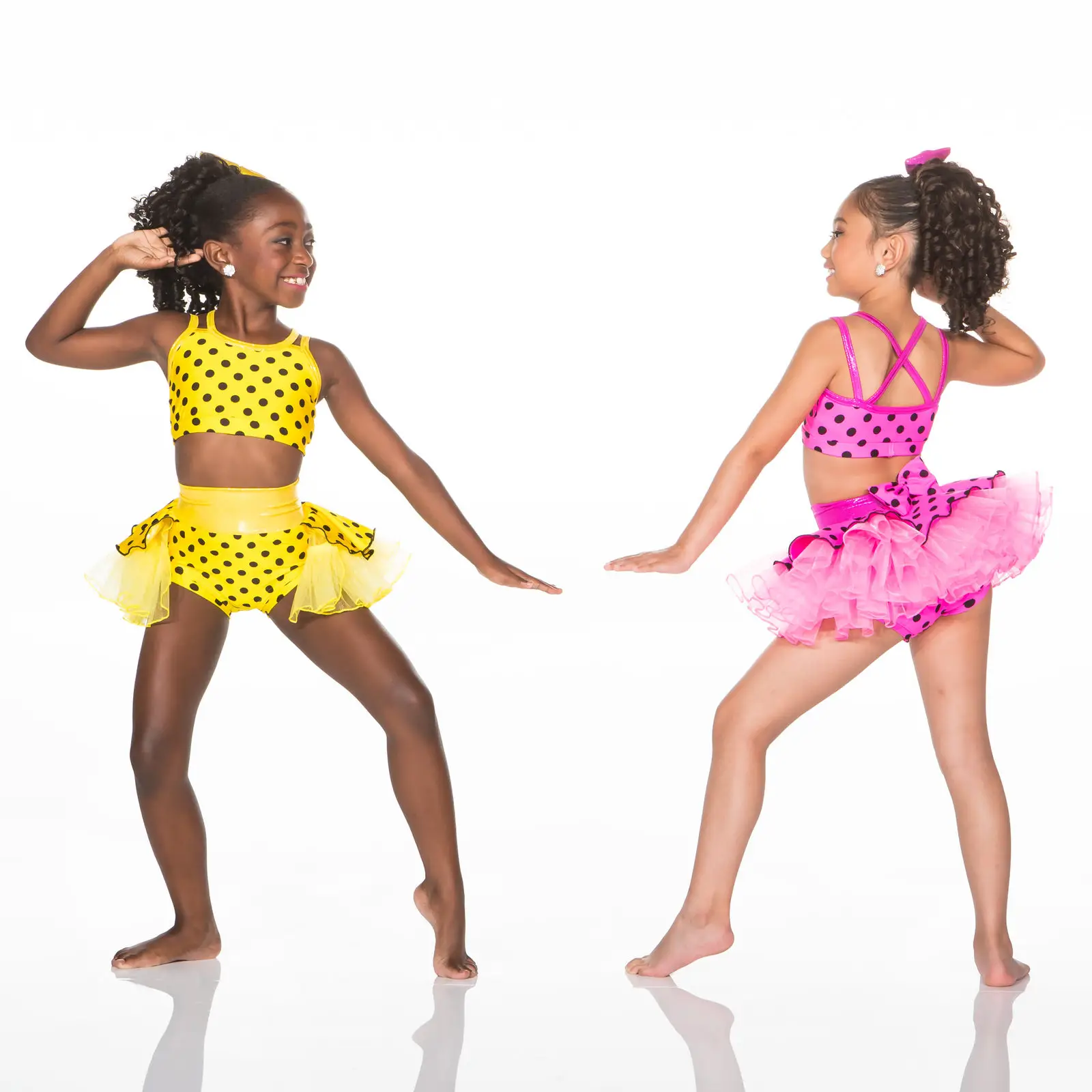 Two girls in colorful polka-dot dance costumes posing