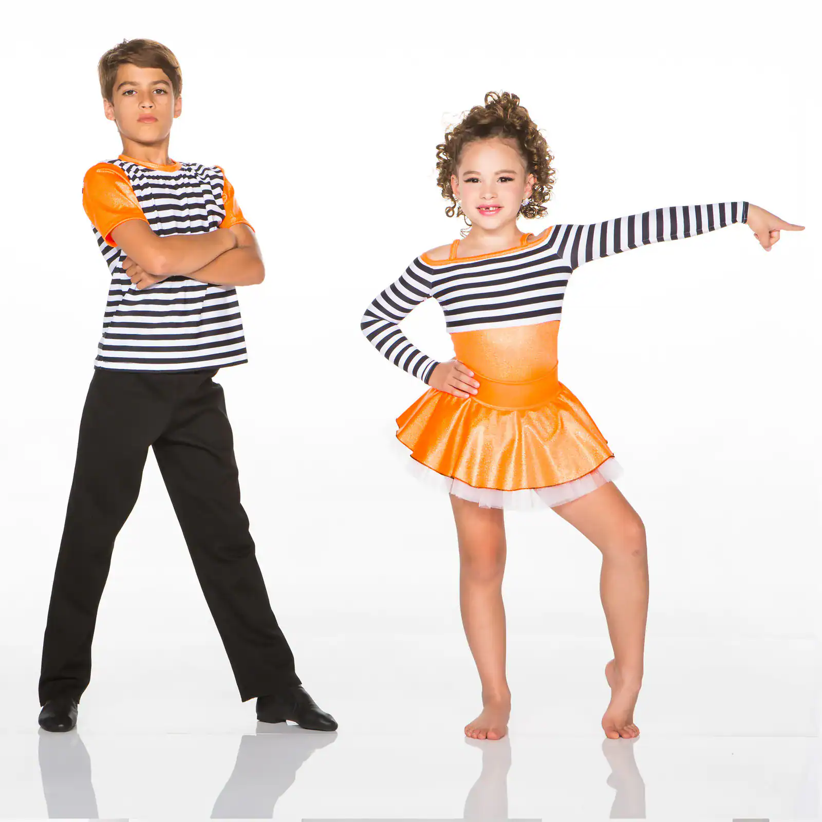 Two children pose in striped orange dance costumes.