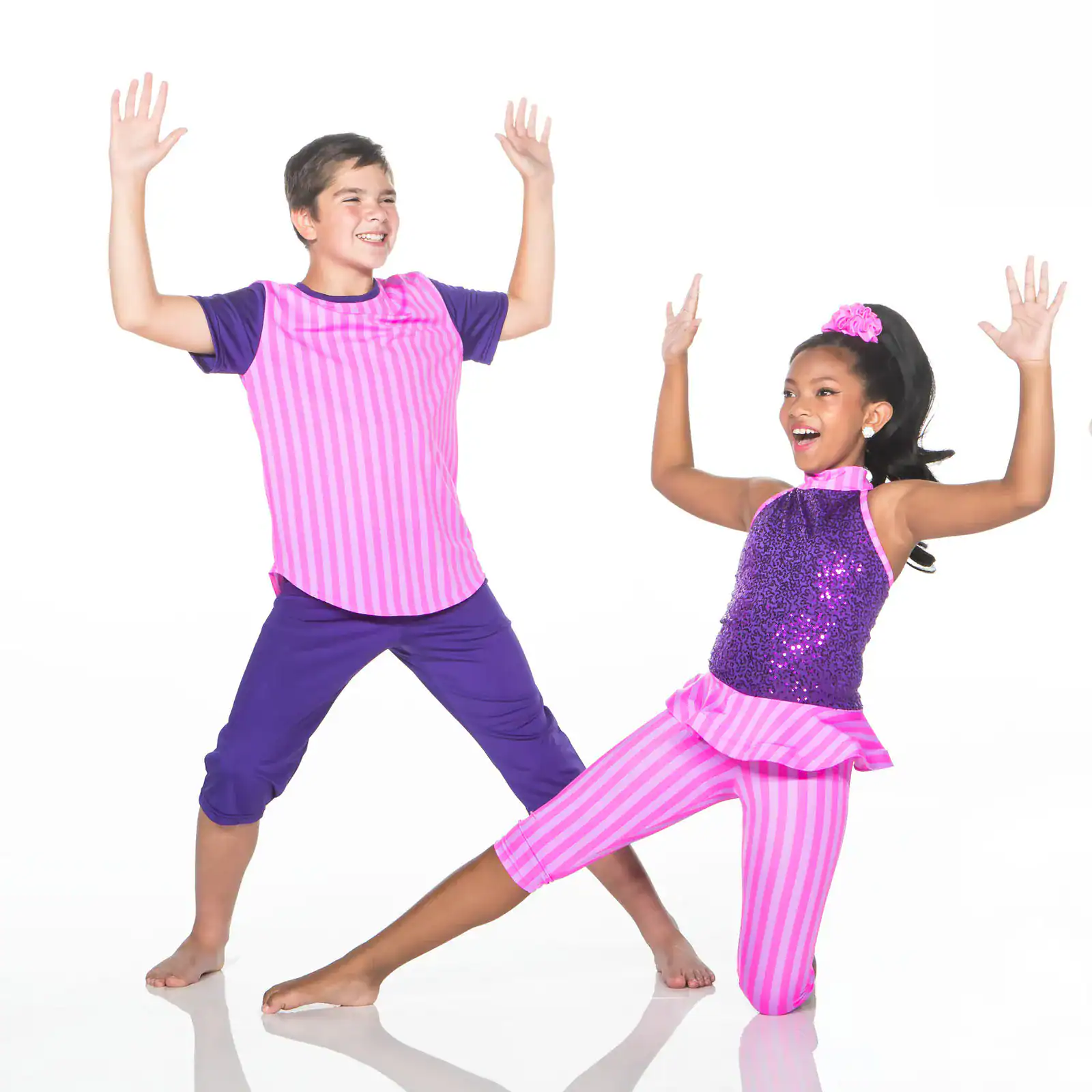 Two children dancing in bright pink and purple costumes