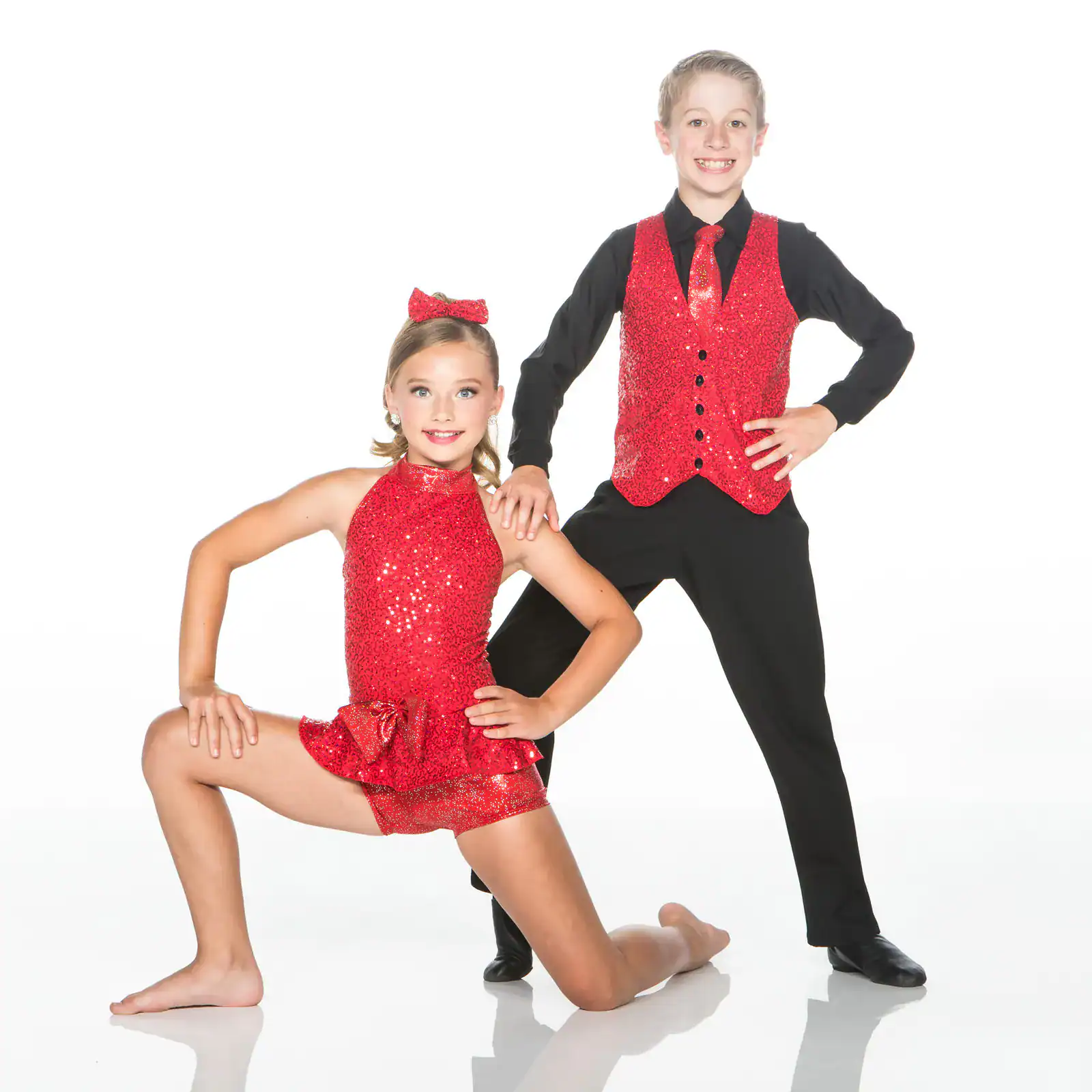 Two young dancers posing in matching red sequined costumes