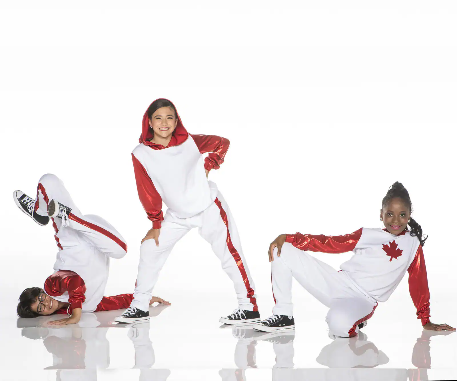 Three dancers in red and white Canada-themed costumes posing