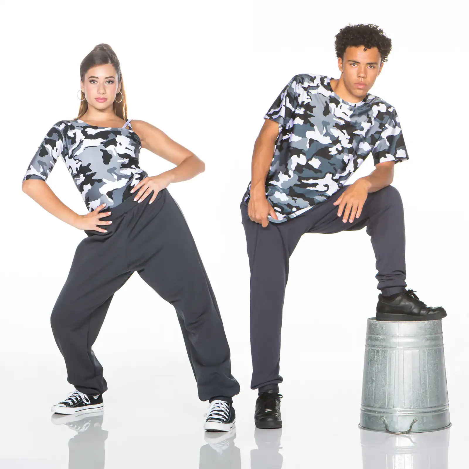 Two models pose in gray camouflage shirts and black pants.